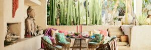 Asian-inspired covered patio with colorful textiles and wicker furniture