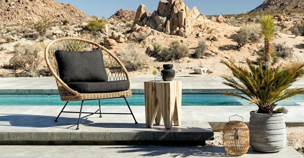 Poolside patio design in the desert with pretty decor and rattan chair