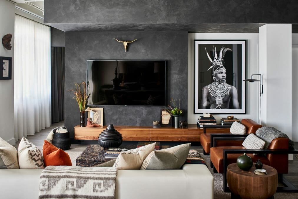 Striking living room design with charcoal walls, leather accent chairs and tribal photograph by one of the top Atlanta interior designers