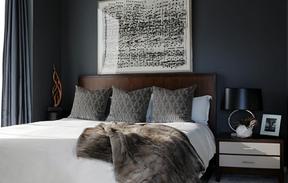 Transitional bedroom design with sheet music as wall art and plush bedding by one of the top Atlanta interior designers