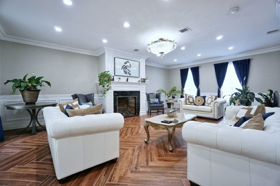 Glamorous traditional home style living room with blue velvet curtains, chandelier and Chesterfield sofas