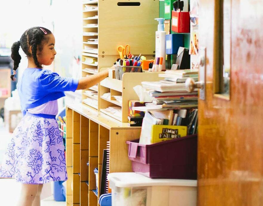 Young girl looking at stationary in a school that could benefit from Donors Choose's gift certificate ideas