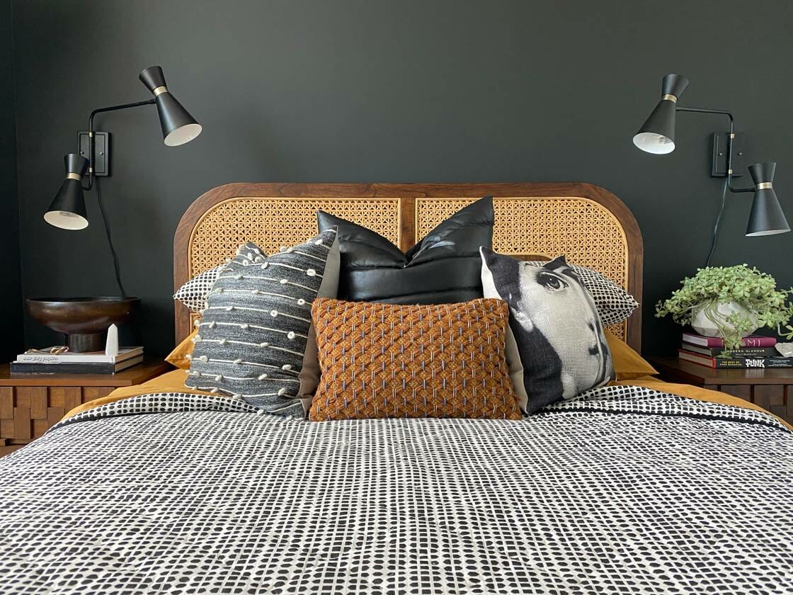 Grey and white bedding on a wicker bed as a CB2 Black Friday furniture sale