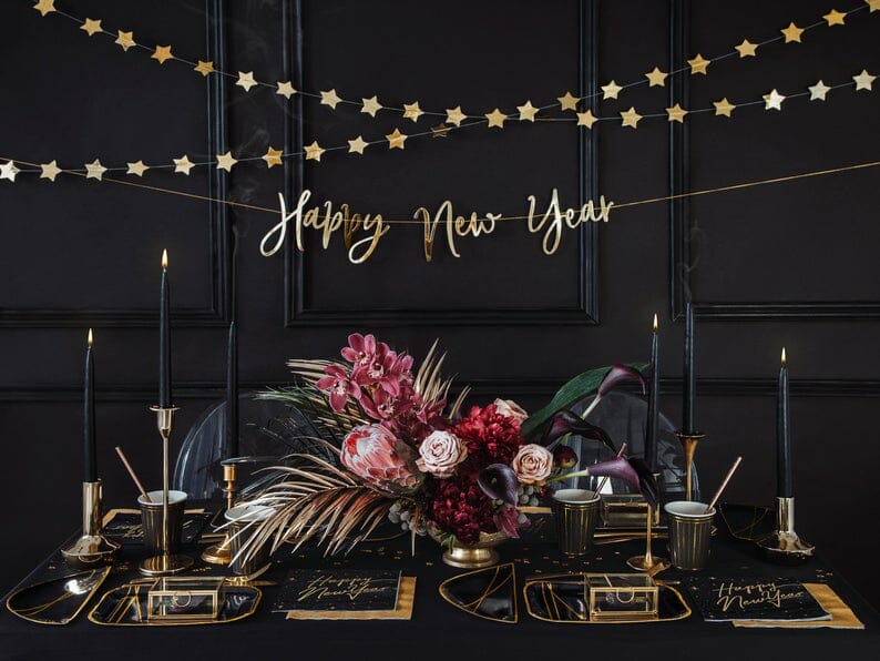 New year wall decoration next to a dramatic black new years dinner table