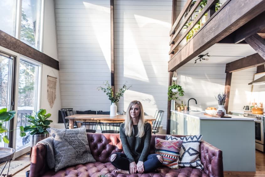 Woman sitting on a leather sofa in a loft apartment