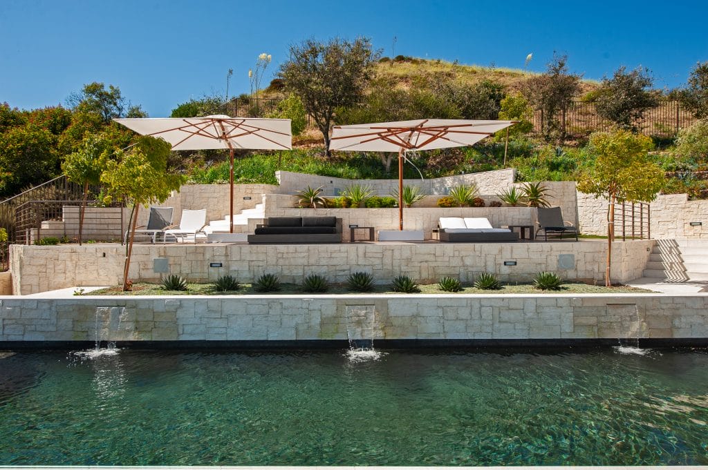 Decorative pool planters in a patio by Decorilla designer, Kristin G.