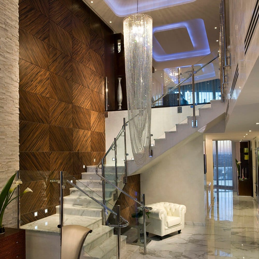 Statement crystal chandelier in a contemporary glamorous entryway by Decorilla designer, Renata P.
