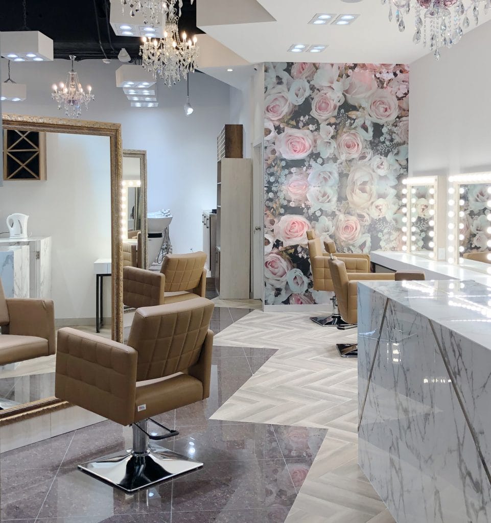 Floral wallpaper accent wall in a salon interior by Decorilla designer, Rosana S.