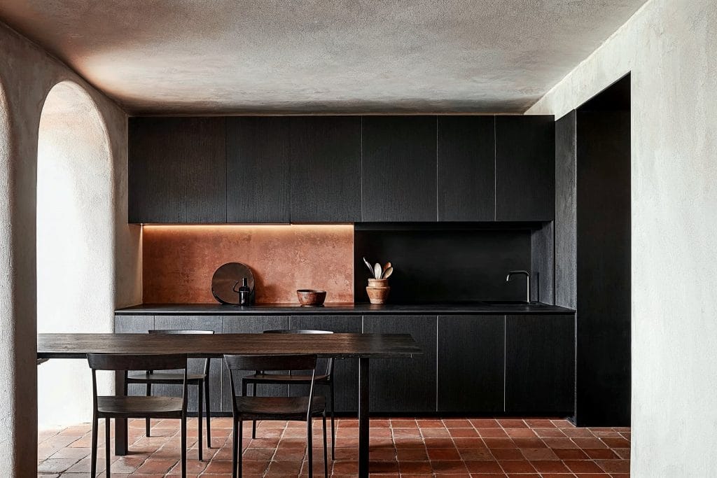 Dramatic cabinet setup as an accent wall by itself, in a kitchen by Decorilla
