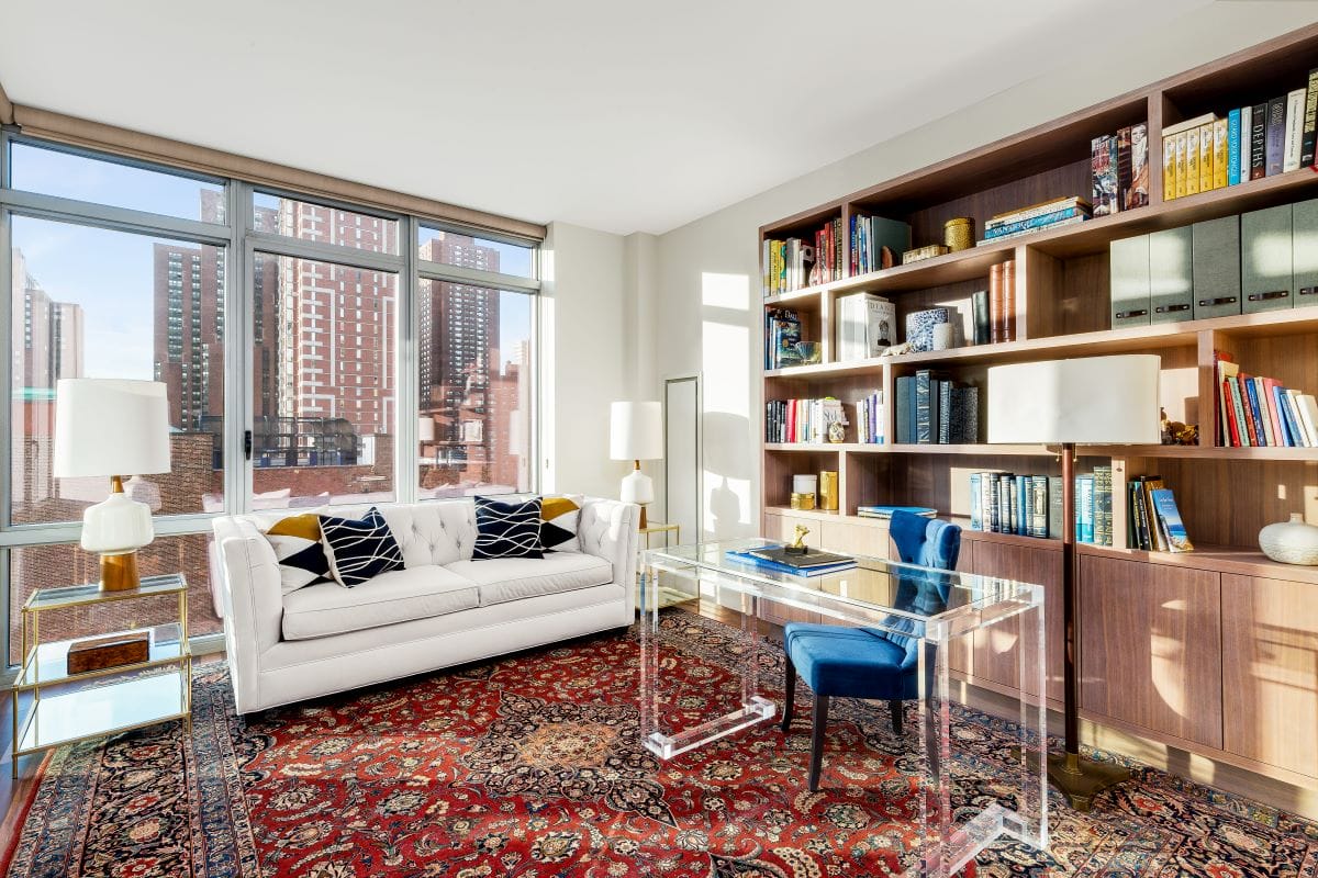 Stylish home office with a library designed by Decorilla