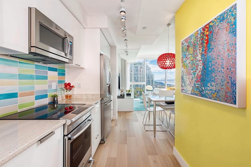 Colorful galley style kitchen by Decorilla
