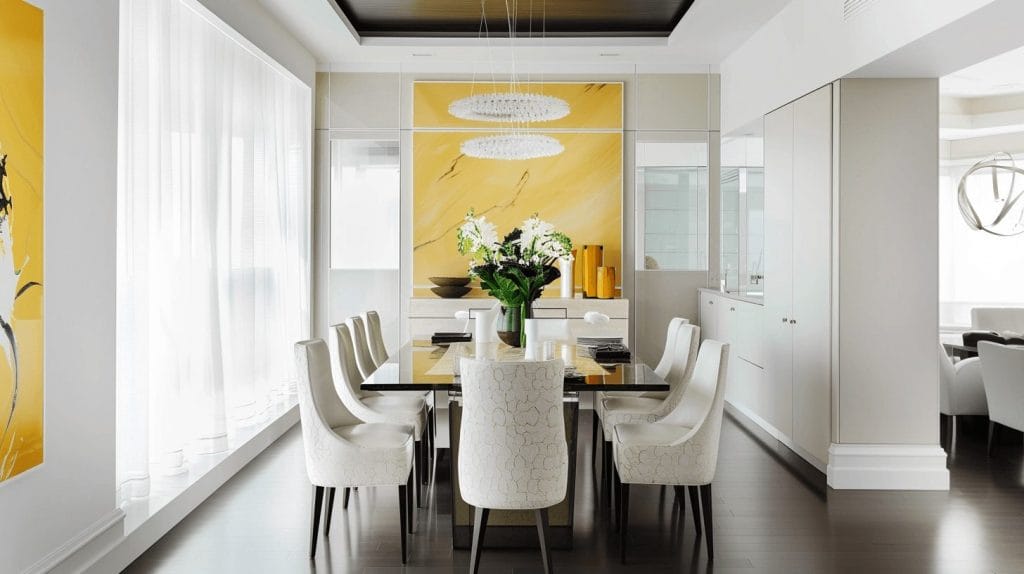 Glass tabletop and trending dining chairs in a stylish setup by Decorilla