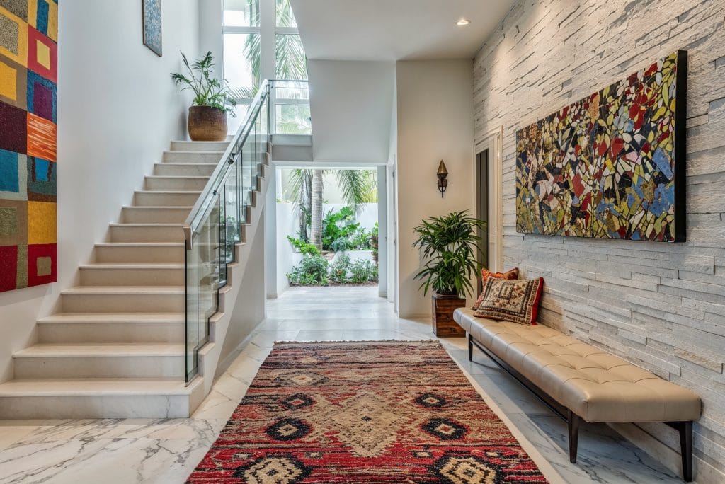 A hallway by Decorilla using art in interior design to transcend patterns and colors
