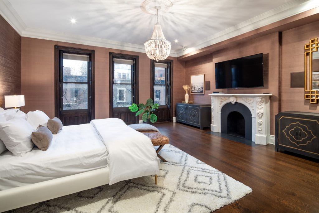 Eclectic primary bedroom design ideas with a fireplace, by Decorilla designer, Chandler H.