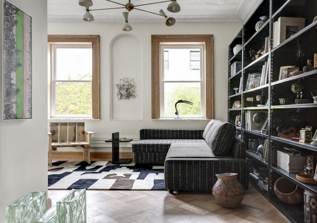 Eclectic lounge with intentional clutter in bookshelves by DECORILLA designer, Catherine W. 