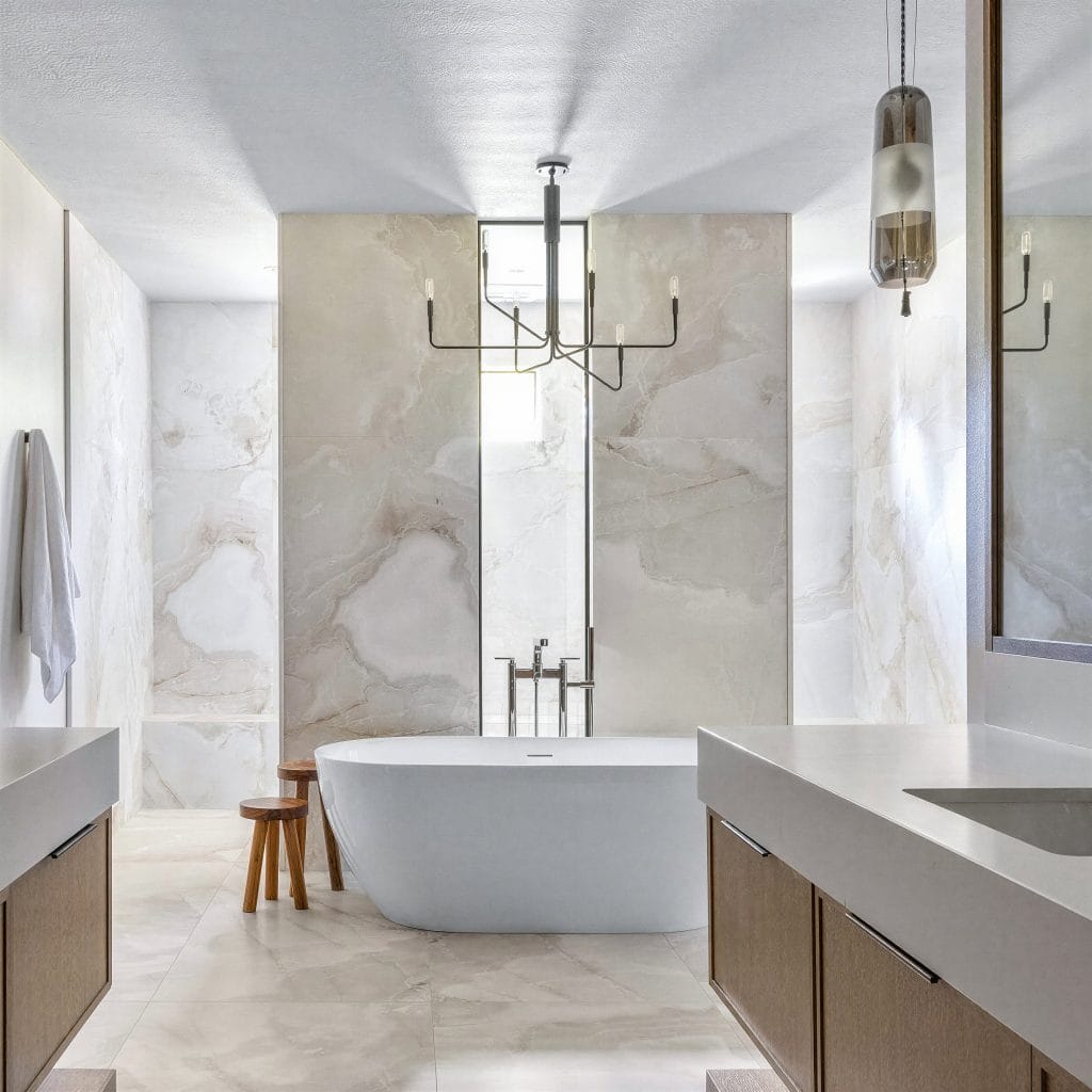 Marble-clad primary bathroom ideas by Decorilla designer, Danielle E.