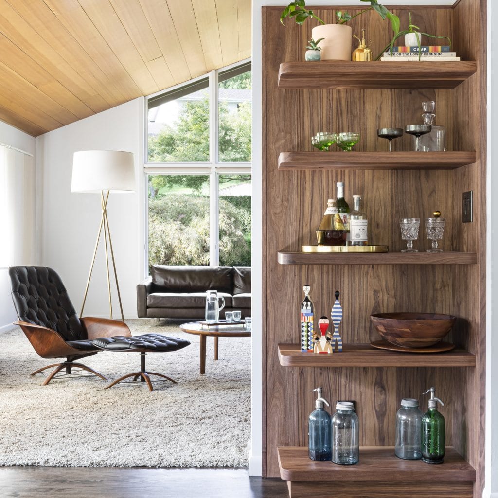 Vertical half-wall with shelving dividing a broken floor layout by Decorilla designer, Sierra H.