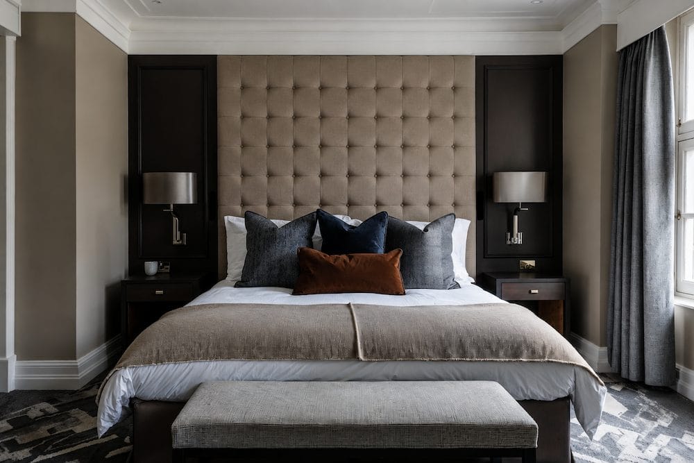 Masculine accent wall in master bedroom retreat by Decorilla