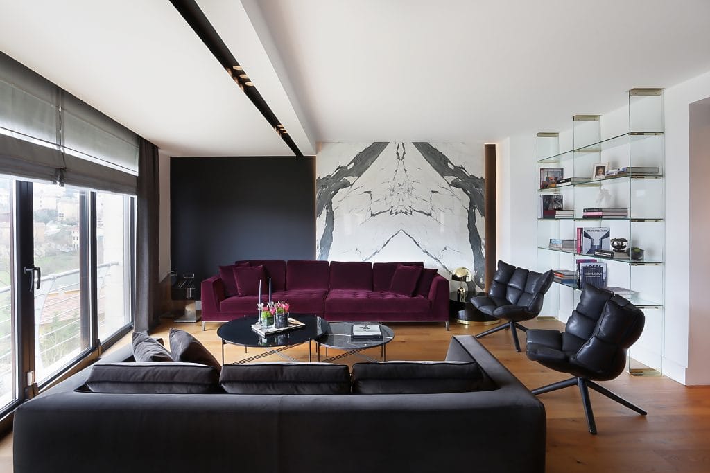 Veined marble against charcoal living room paint in an interior by Decorilla designer, Meric S.